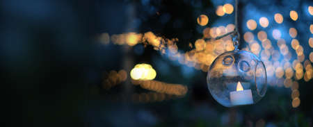 Beautiful evening garden party glass ornaments with candle bokeh of festive light backgroundの写真素材