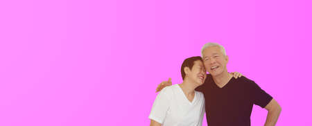 Asian senior couple hugging studio shot banner with copu spaceの写真素材