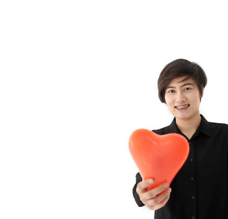 Cool Asian short hair braced woman holding red heart love balloon showing happy expressionの写真素材
