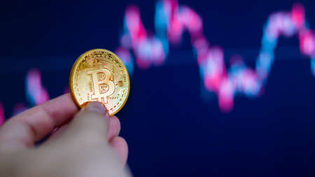 Hand holding golden coin crypto currency stock trade graph background new invest market