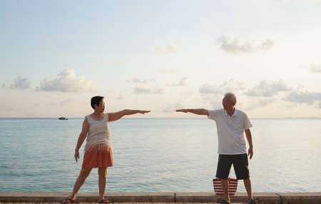 Asian elder senior couple retirement fun beach ocean trip healthy relationship and financialの写真素材