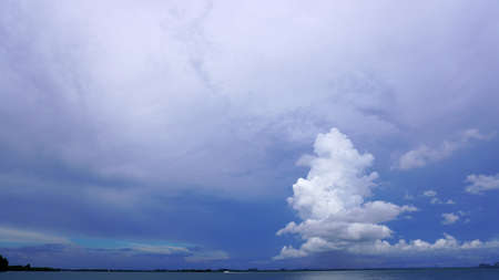 Tall cone tree shape cloud over ocean horizon skyの写真素材