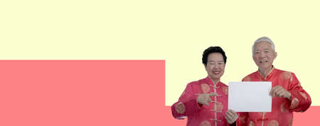 Asian senior couple Chinese new year costume holding blank sign for advertising textの写真素材