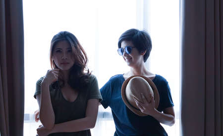 two Asian women casual summer fashion relax and fun together at homeの写真素材