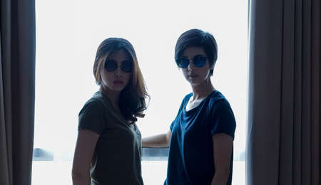 two Asian women casual summer fashion relax and fun together at homeの写真素材