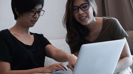 Two entrepreneur Asian woman glasses working from anywhere with laptop computerの写真素材