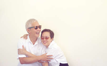 Happy Asian senior couple laughing smiling together white background bannerの写真素材