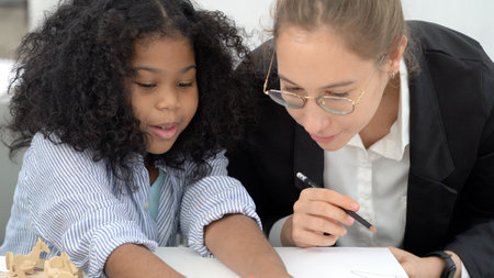 Creative class in diversity school Caucasian teacher with African kid having fun learning critical thinking global citizen education conceptualの写真素材