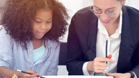 Creative class in diversity school Caucasian teacher with African kid having fun learning critical thinking global citizen education conceptualの写真素材