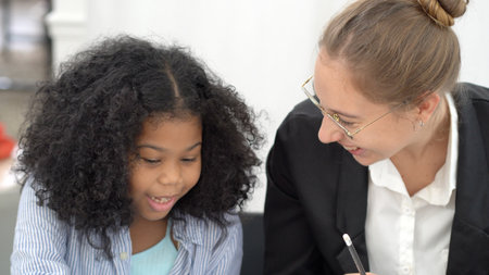 Creative class in diversity school Caucasian teacher with African kid having fun learning critical thinking global citizen education conceptualの写真素材