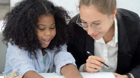 Creative class in diversity school Caucasian teacher with African kid having fun learning critical thinking global citizen education conceptualの写真素材