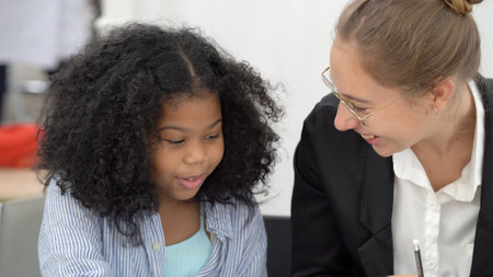 Creative class in diversity school Caucasian teacher with African kid having fun learning critical thinking global citizen education conceptualの写真素材
