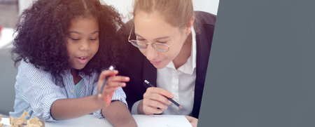 Creative class in diversity school Caucasian teacher with African kid having fun learning critical thinking global citizen education conceptualの写真素材