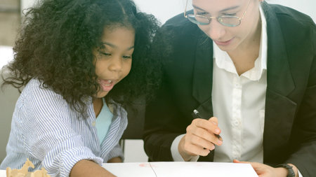 Creative class in diversity school Caucasian teacher with African kid having fun learning critical thinking global citizen education conceptualの写真素材