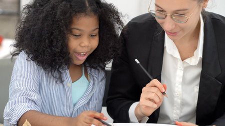 Creative class in diversity school Caucasian teacher with African kid having fun learning critical thinking global citizen education conceptualの写真素材