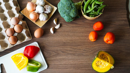 Flay lay food cooking vegetable broccoli egg pepper pea garlic background on wood texture text copy spaceの写真素材