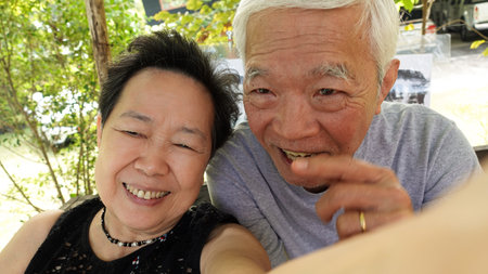 Asian senior elder couple taking selfie together fun retire trip together lifestyleの写真素材