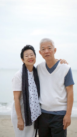 Asian senior couple romantic moment at beach ocean love retirement holiday date