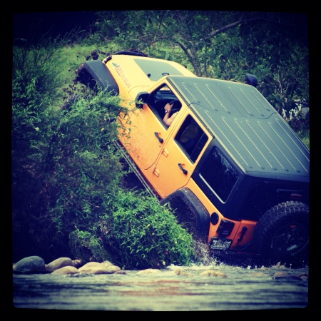 Jeep crawling after crossing a riverの素材