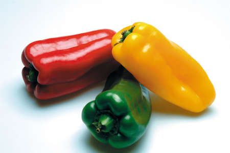 red green and yellow bell peppers on white backgroundの写真素材