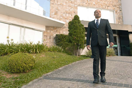 Black businessman in a suit looking successfull in an urban backgroundの写真素材