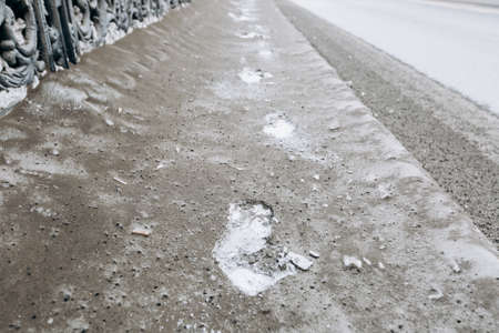 footprints on dirty snow in the cityの写真素材