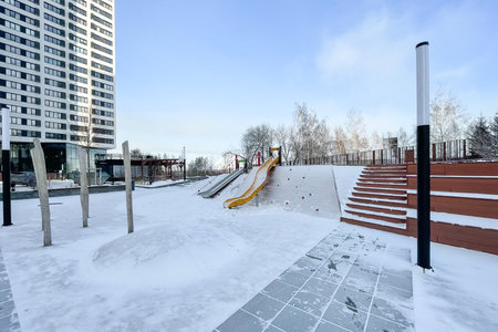 Snow-covered children's playground in the city park in winter.の写真素材