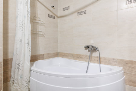 modern bathroom with bathtub and decorative wall tilesの写真素材
