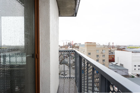 the balcony of an apartment on the upper floors of an apartment buildingの写真素材
