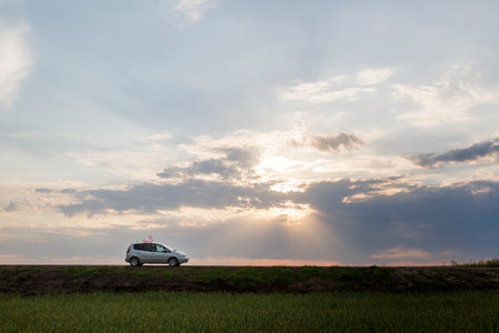 Car in the field at sunset. Concept of transportation and travel.の写真素材
