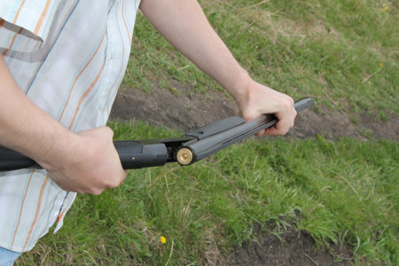 A man with a lawn mower in his hand. Close-up.の写真素材