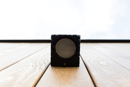 black lamp on the wooden facade of a house with rain or dew dropsの写真素材