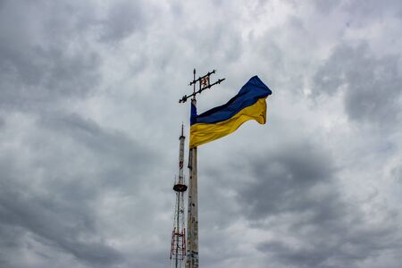 Ukraine flag waving on a background of gray sky with cloudsの写真素材