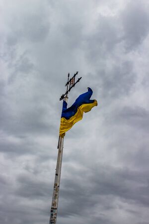 Ukraine flag waving on a background of gray sky with cloudsの写真素材