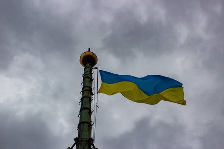 Ukraine flag waving on a background of gray sky with cloudsの写真素材
