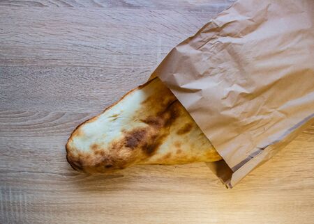 Georgian and Armenian lavash slightly burnt lying on the table in a gray paper bag.の写真素材