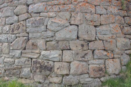 Brick wall overgrown with grass and moss. Pledged window with red brick.の写真素材