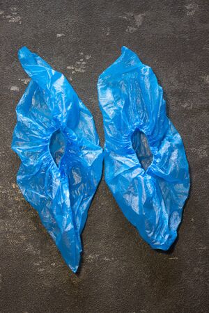 Blue medical shoe covers on a black background. Virus and Flu Controlの写真素材