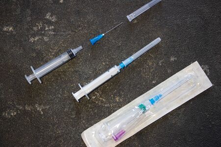 Coronavirus and flu remedy. Medical syringes on a black background.の写真素材