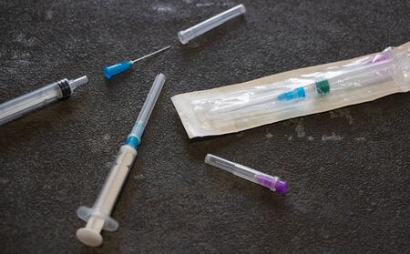 Coronavirus and flu remedy. Medical syringes on a black background.の写真素材