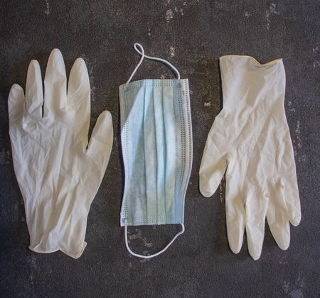 Coronavirus and Flu Control. Medical mask and rubber gloves on a black background.の写真素材