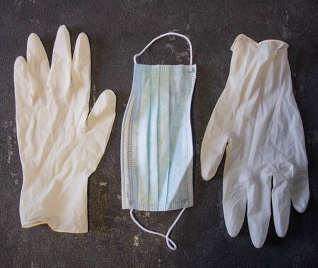 Coronavirus and Flu Control. Medical mask and rubber gloves on a black background.の写真素材