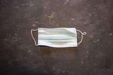 Coronavirus and Flu Control. Medical mask on a black background.
