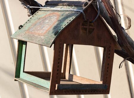 birdhouse for birds tied to a vine branch and a metal pipeの写真素材