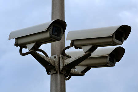 video surveillance cameras on a column against the background of the blue sky