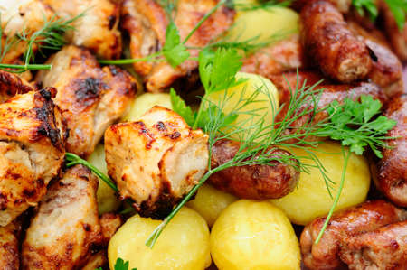 tasty chicken kebab with sausages and potatoesの写真素材