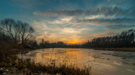 mysterious sunset over the freezing marshy lake late autumn. landscapeの写真素材