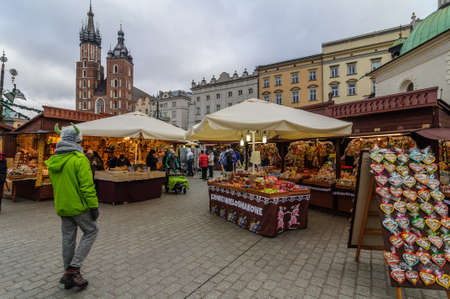 KRAKOW, POLAND - DEC. 29, 2016: Christmas fair in the Market Square along the Krakow Cloth Hall near the town hall in cloudy weatherのeditorial素材