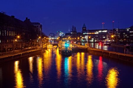 Night time lights on the Spree river as a ferry crosses into a lock.の写真素材