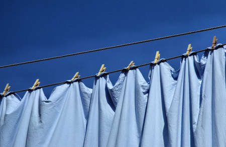 Blue cloth pegs under a blue sky.の写真素材